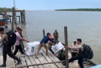 Sukseskan pungut suara Pemilu 2024, Personil Polsek Rupat Utara bahu membahu gotong kotak suara ke TPS sangat rawan di Dusun Hutan Samak Desa Titi Akar