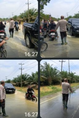Personel Polsek Padang Tualang, Polres Langkat, Polda Sumatera Utara, bergerak cepat melakukan pengaturan lalu lintas di tengah kondisi banjir