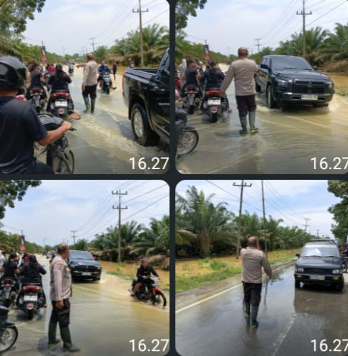 Personel Polsek Padang Tualang, Polres Langkat, Polda Sumatera Utara, bergerak cepat melakukan pengaturan lalu lintas di tengah kondisi banjir